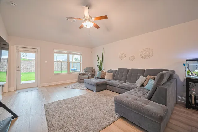 a living room with furniture and wooden floor
