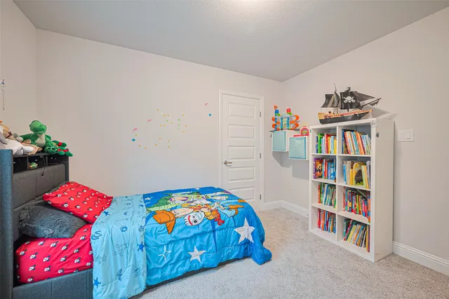 a bedroom with a bed and a bookshelf