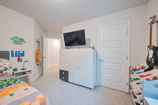 a view of a bedroom with baby bed and workspace