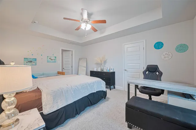 a spacious bedroom with a bed and a chandelier