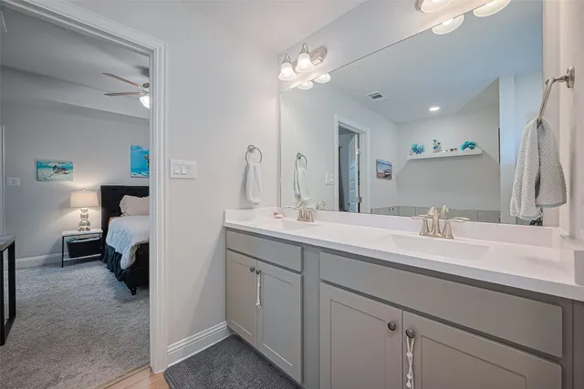 a en suite bathroom with a double vanity sink and a mirror