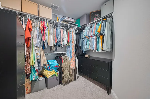 a view of walk in closet with clothes and shoes