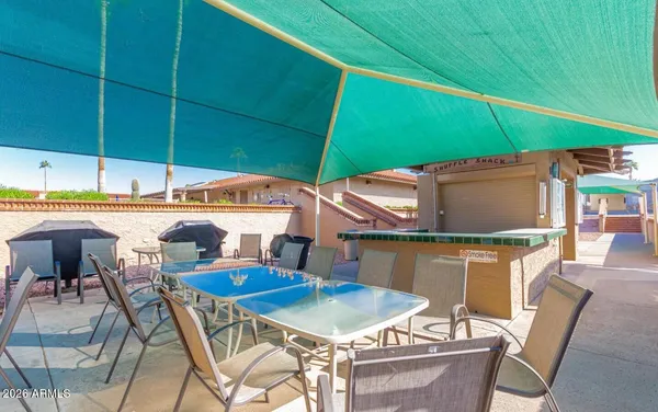 a view of a patio with a table and chairs under an umbrella