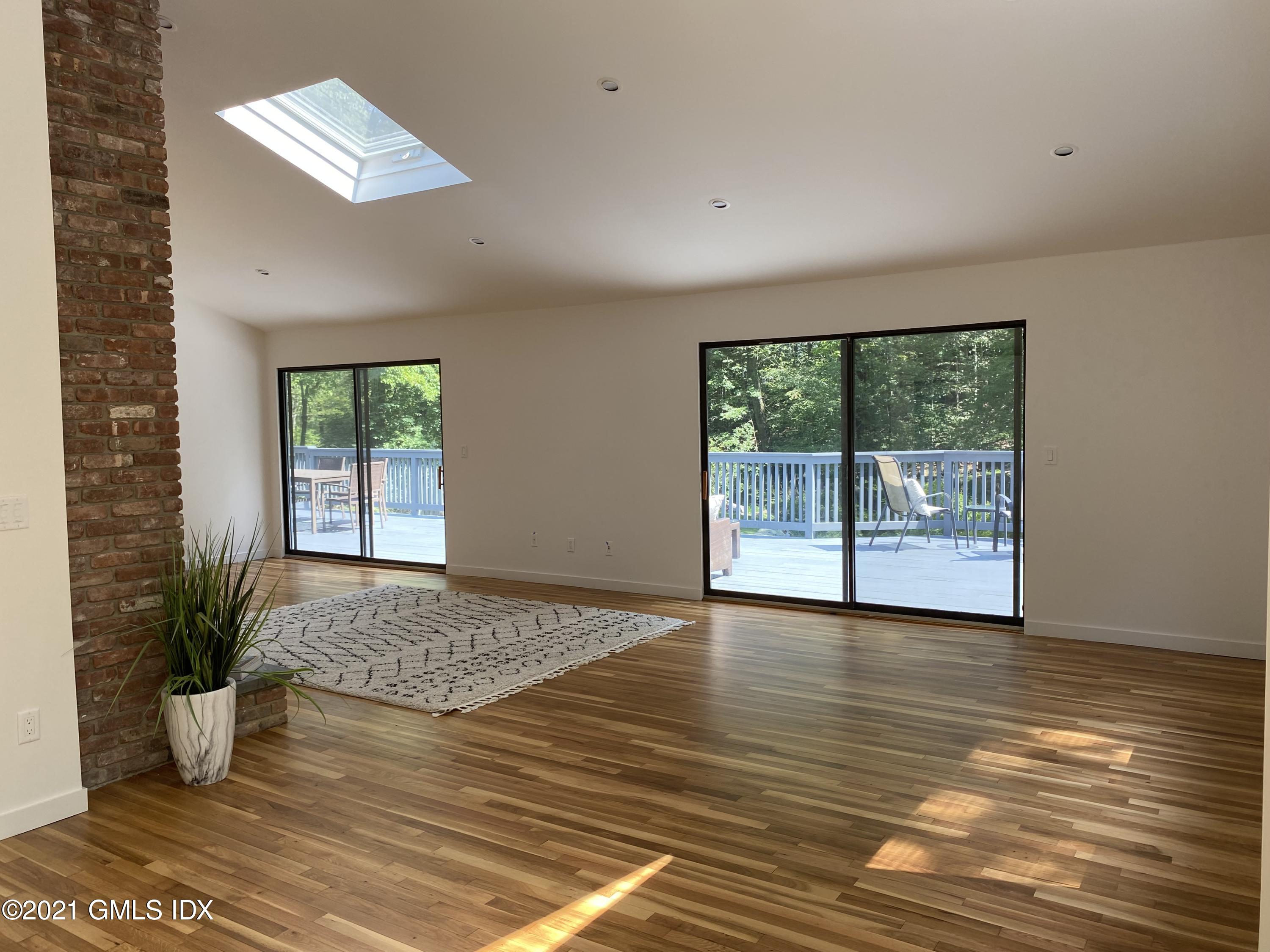 297 Cognewaugh Road Cos Cob, CT 06807 - Photo 3 of 25 a view of an empty room with a window and wooden floor