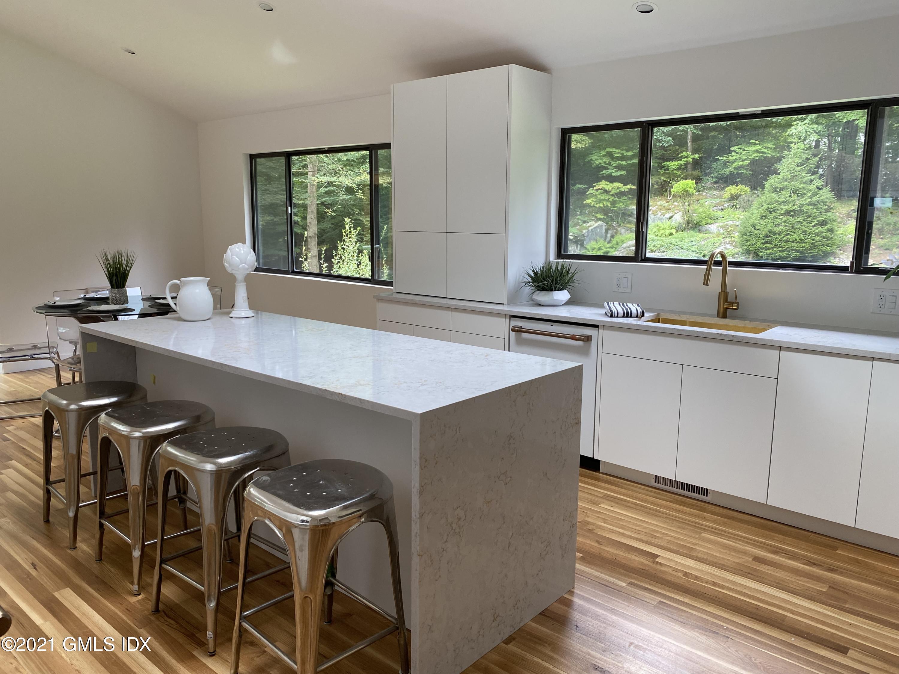 297 Cognewaugh Road Cos Cob, CT 06807 - Photo 7 of 25 a kitchen with a table chairs sink and cabinets