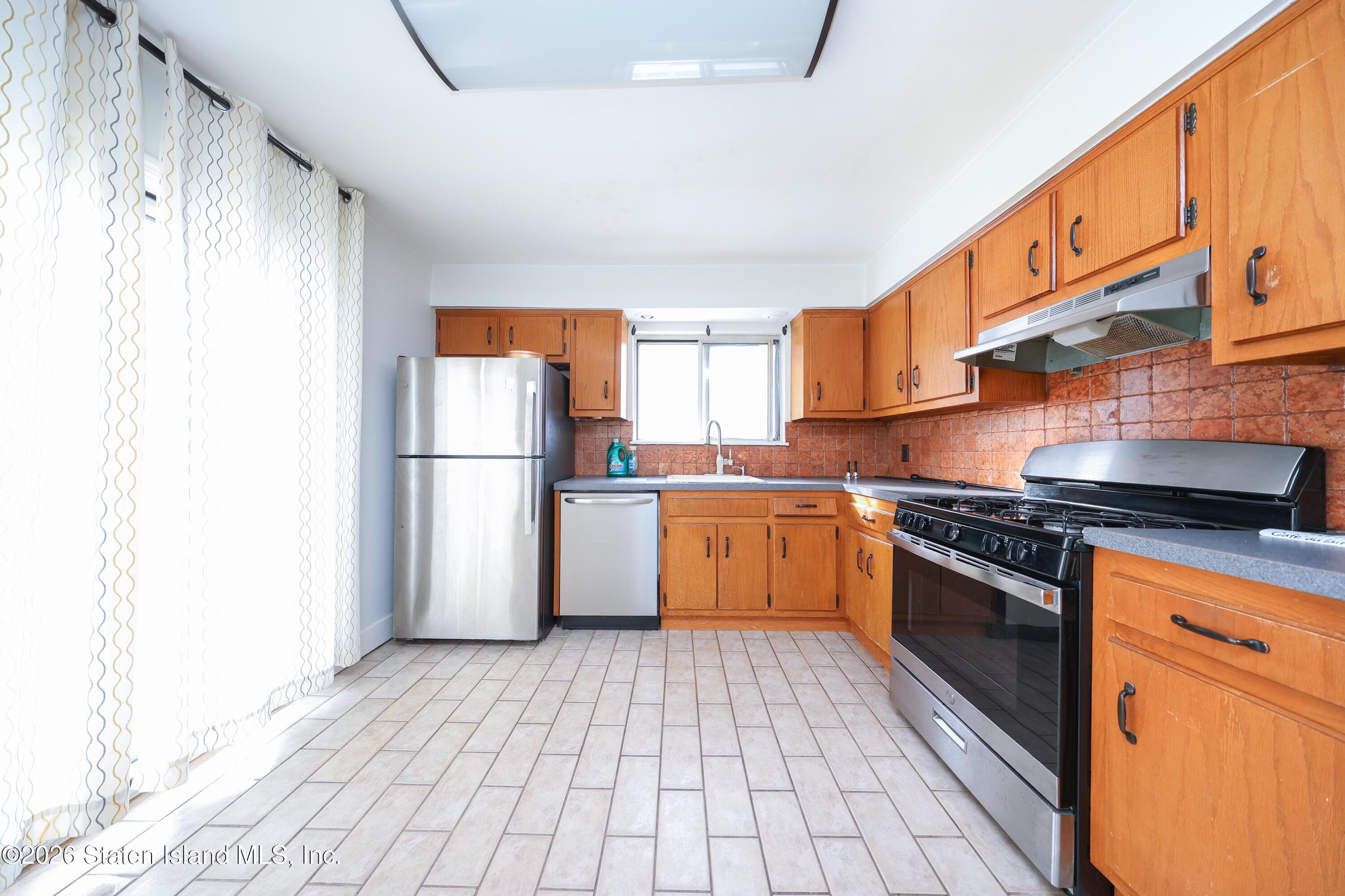 314 Harold Street Staten Island, NY 10314 - Photo 13 of 24 a kitchen with granite countertop a refrigerator and a stove top oven