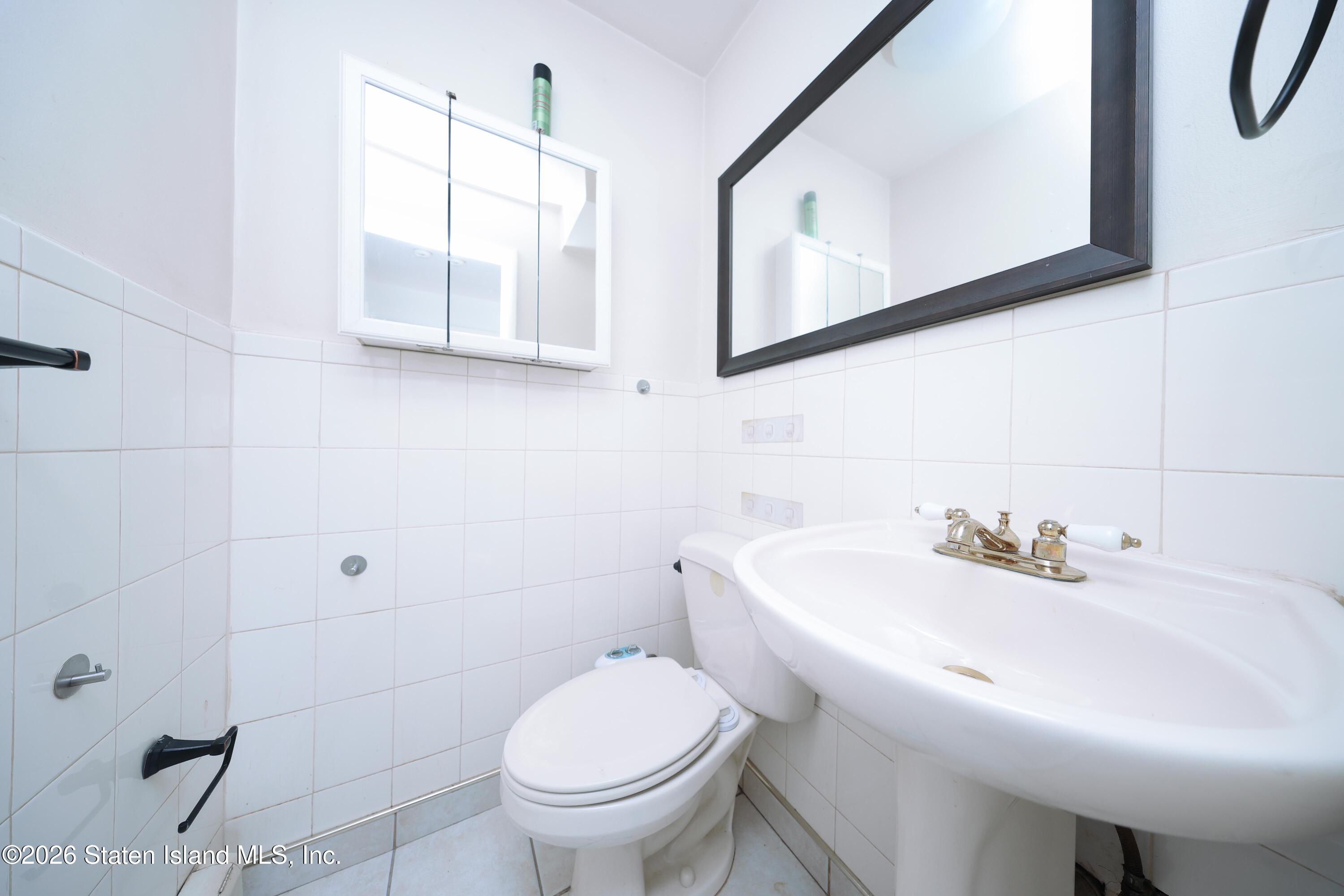 314 Harold Street Staten Island, NY 10314 - Photo 16 of 24 a bathroom with a sink a toilet and mirror