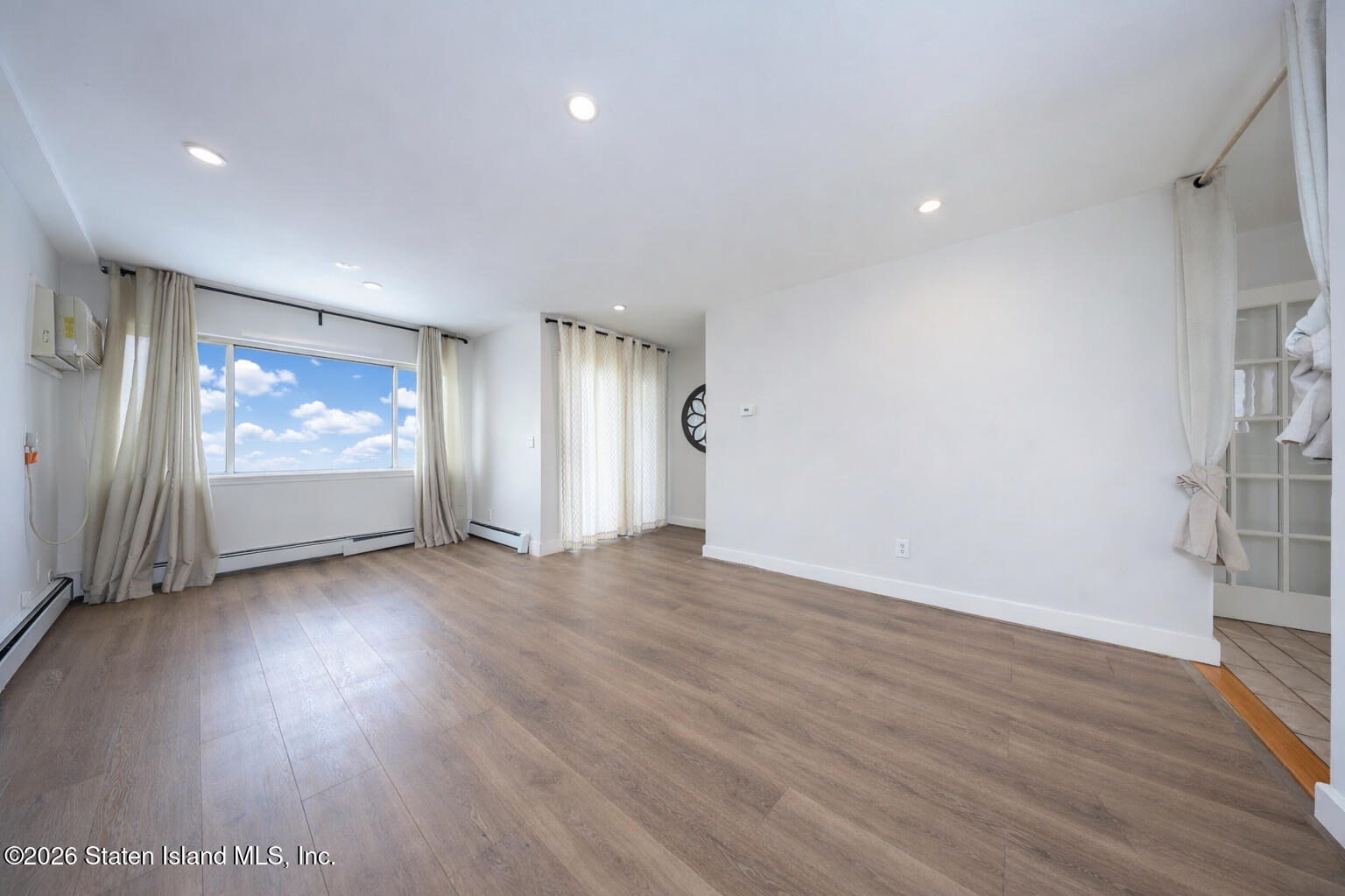 314 Harold Street Staten Island, NY 10314 - Photo 7 of 24 an empty room with wooden floor and windows