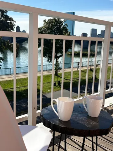 a view of a balcony with wooden floor and outdoor seating