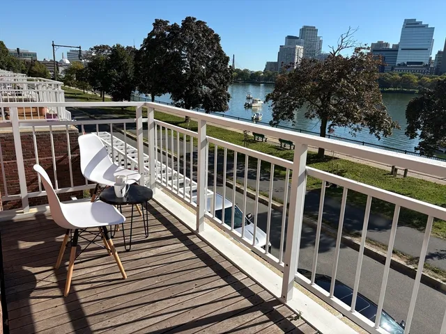 a view of a balcony with wooden floor and outdoor seating