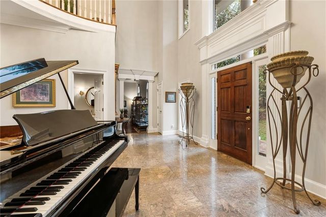 a view of a dining room and livingroom with furniture wooden floor a chandelier