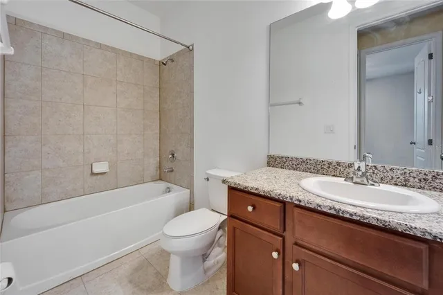 a bathroom with a granite countertop sink a mirror and a bathtub