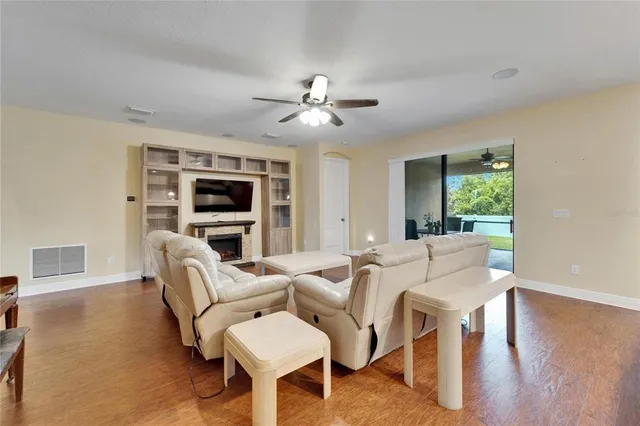 a living room with furniture kitchen and a wooden floor