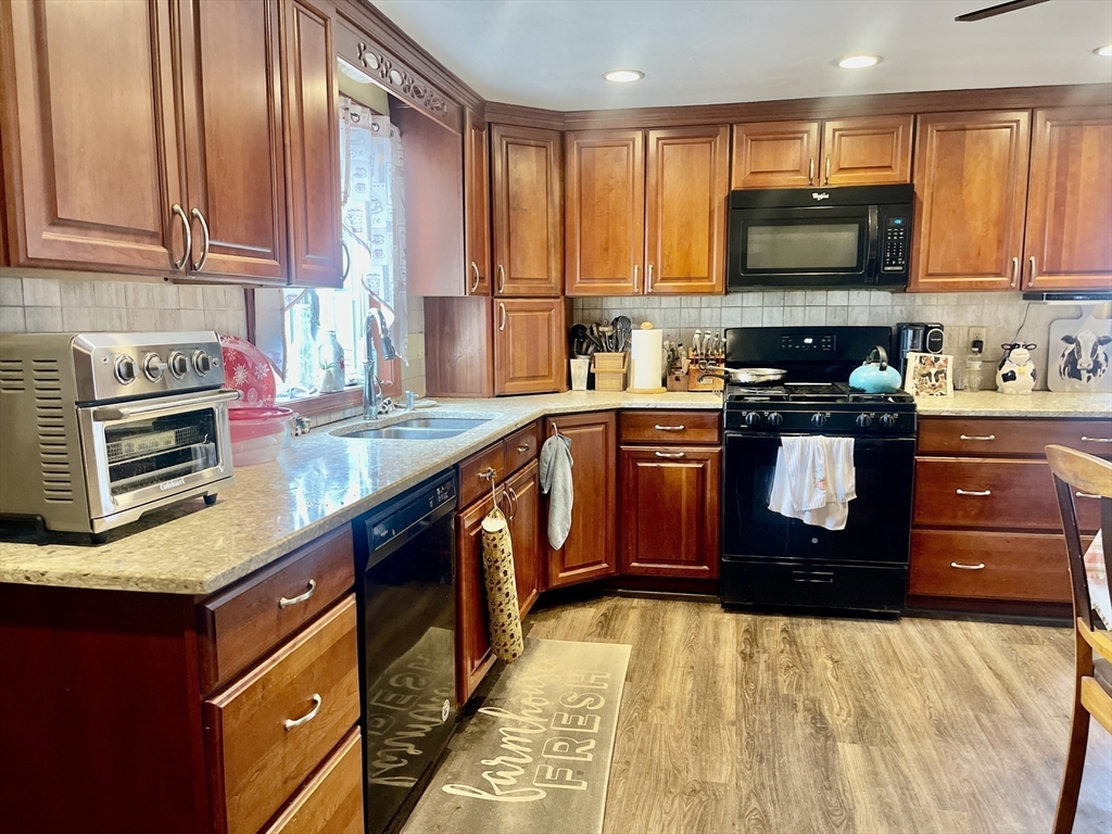 70 Wheaton Avenue Rehoboth, MA 02769 - Photo 11 of 42 a kitchen with stainless steel appliances granite countertop a stove a sink and a microwave