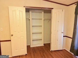 1572 Triple T Drive Dewy Rose, GA 30634 - Photo 14 of 18 a view of an empty room with wooden floor and a door