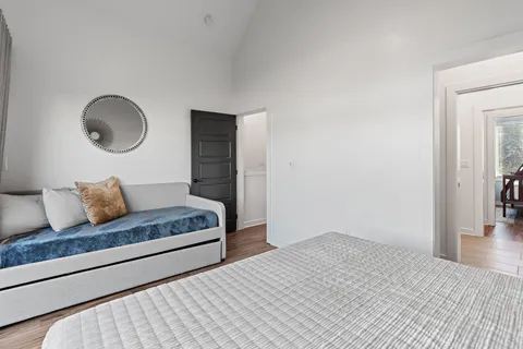a bedroom with a large bed and wooden floor
