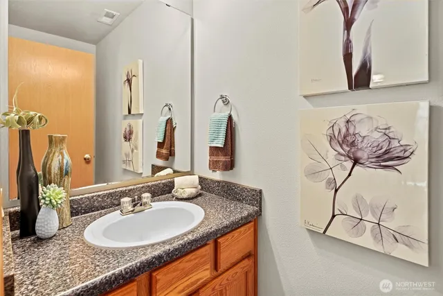a bathroom with a granite countertop sink and a mirror