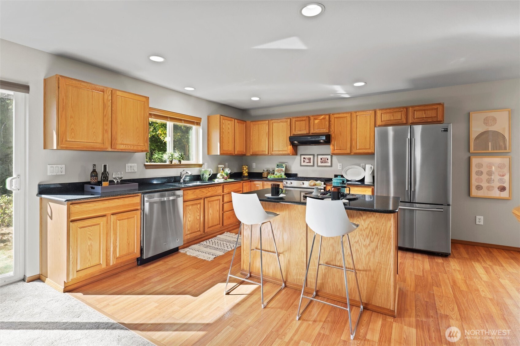 19002 13th Avenue Southeast Bothell, WA 98012 - Photo 9 of 36 a kitchen with stainless steel appliances granite countertop a refrigerator a stove top oven a sink dishwasher and white cabinets with wooden floor