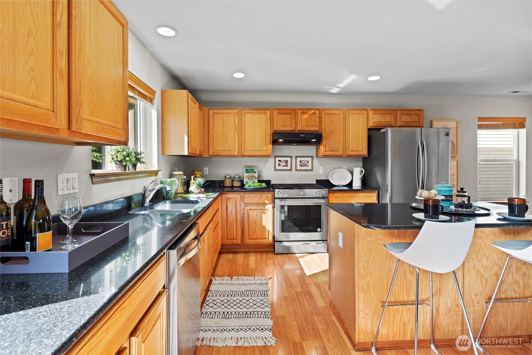 19002 13th Avenue Southeast Bothell, WA 98012 - Photo 10 of 36 a kitchen with stainless steel appliances kitchen island granite countertop a sink and cabinets