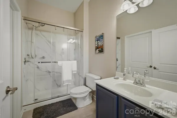 a bathroom with a granite countertop sink toilet and shower