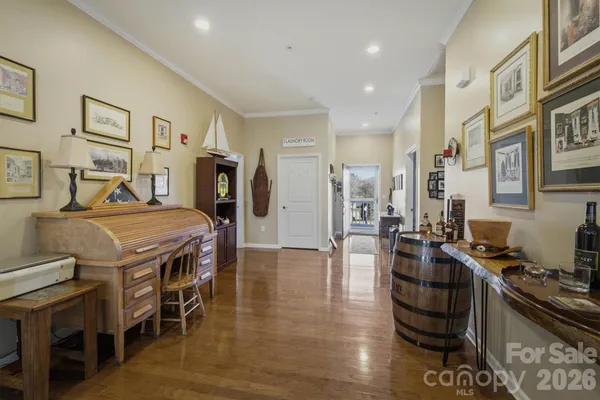 a kitchen with stainless steel appliances granite countertop a stove top oven a refrigerator a dining table and chairs with wooden floor