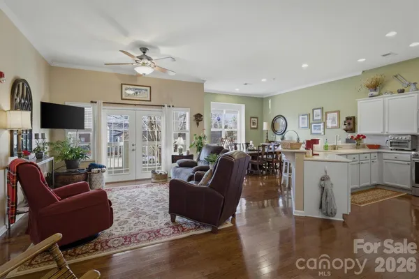 a living room with furniture kitchen view and a chandelier