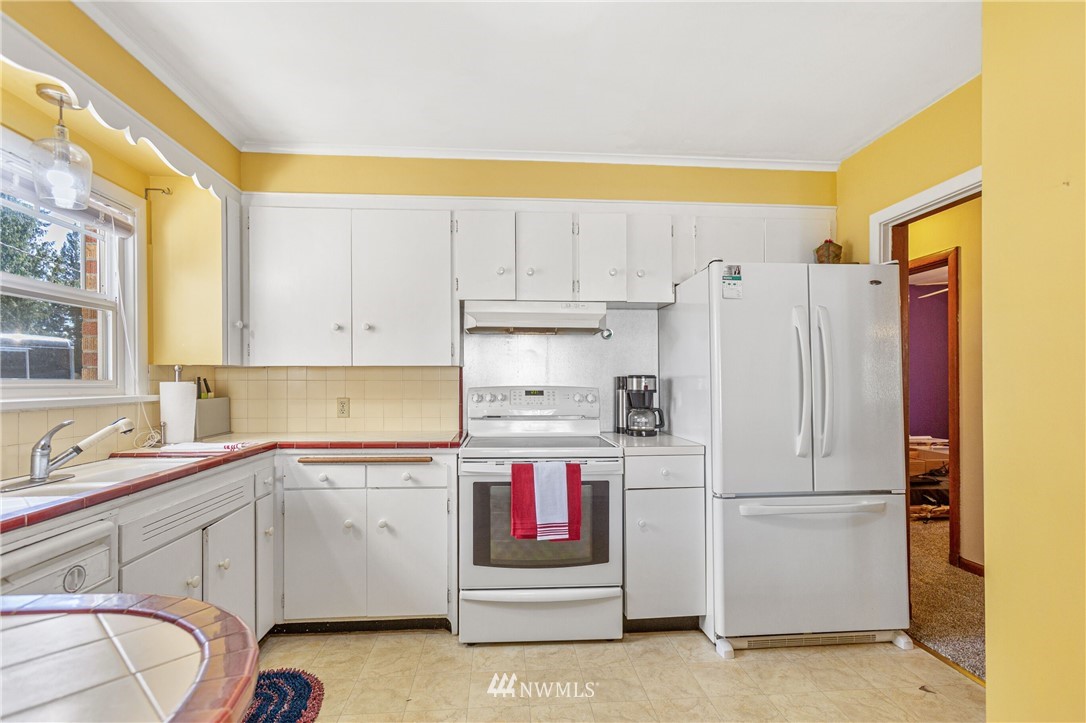 7011 Cady Road Everett, WA 98203 - Photo 18 of 32 a kitchen with cabinets and white appliances