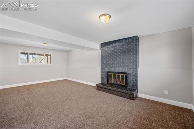 6319 Chippewa Road Colorado Springs, CO 80915 - Photo 31 of 36 Unfurnished living room with carpet floors and a fireplace