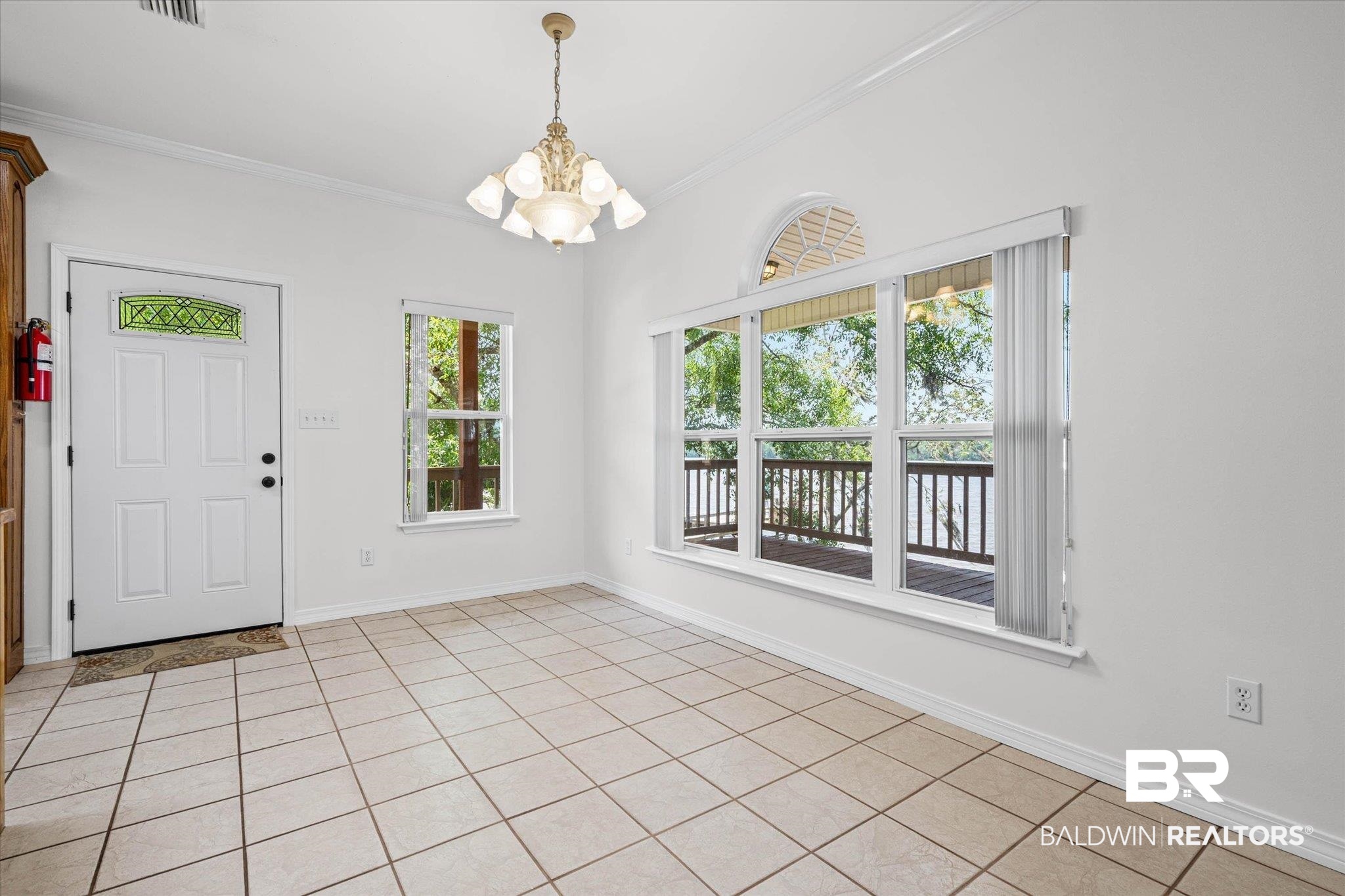 41923 Bayou Road Bay Minette, AL 36507 - Photo 12 of 35 Spacious interior room featuring light-colored tile flooring, white walls, and a multi-light chandelier