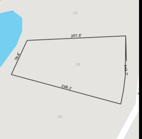 a view of a dry yard with wooden fence