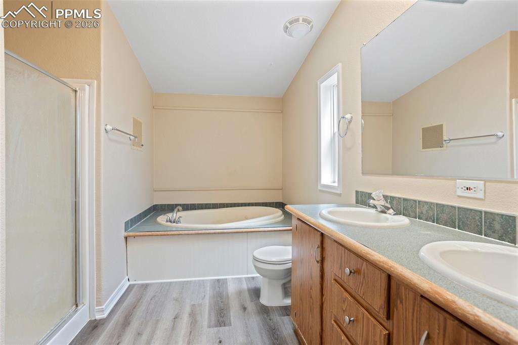 7765 Valley Quail Point Colorado Springs, CO 80922 - Photo 24 of 37 a bathroom with a sink a toilet a tub and a mirror