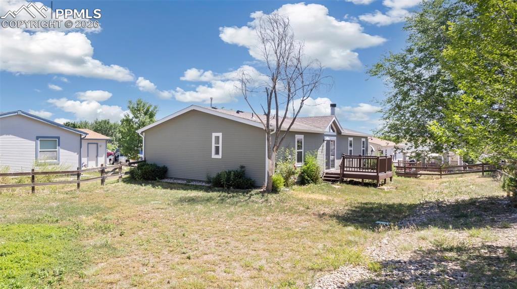 7765 Valley Quail Point Colorado Springs, CO 80922 - Photo 32 of 37 a view of a house with backyard and a tree