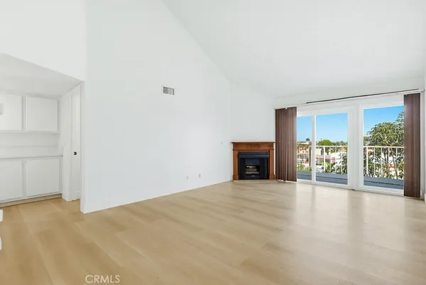 a view of an empty room with a fireplace and a window