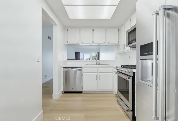 a kitchen with white cabinets and white appliances