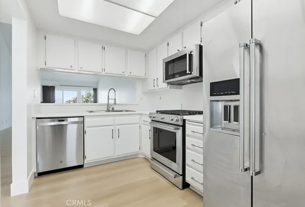 a kitchen with stainless steel appliances white cabinets and a sink