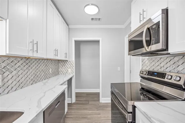 a view of an empty room with wooden floor and a ceiling fan