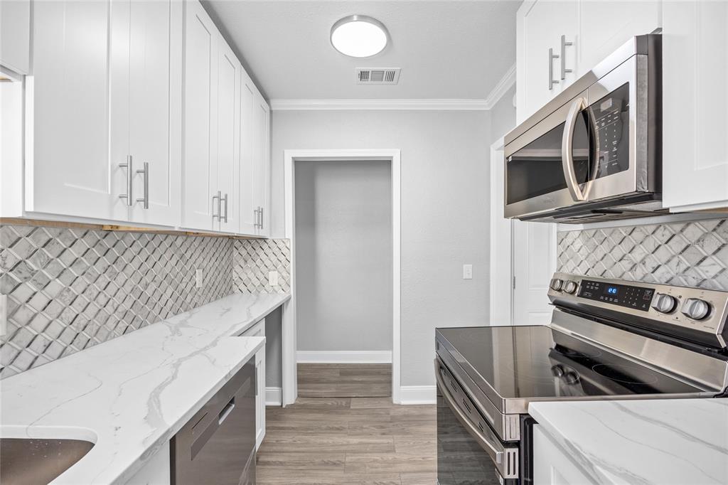 3205 West San Pedro Street, Unit 1 Tampa, FL 33629 - Photo 14 of 35 a kitchen with granite countertop a stove and a microwave