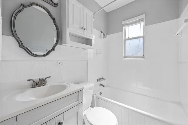 a view of a room with a ceiling fan and wooden floor