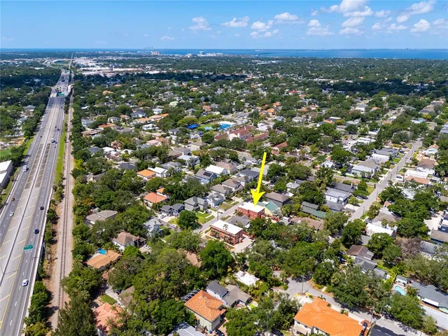 an aerial view of residential houses with outdoor space and parking