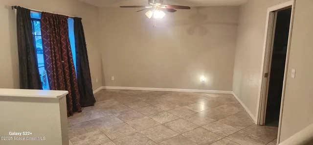 a view of an empty room with wooden floor and a bathroom
