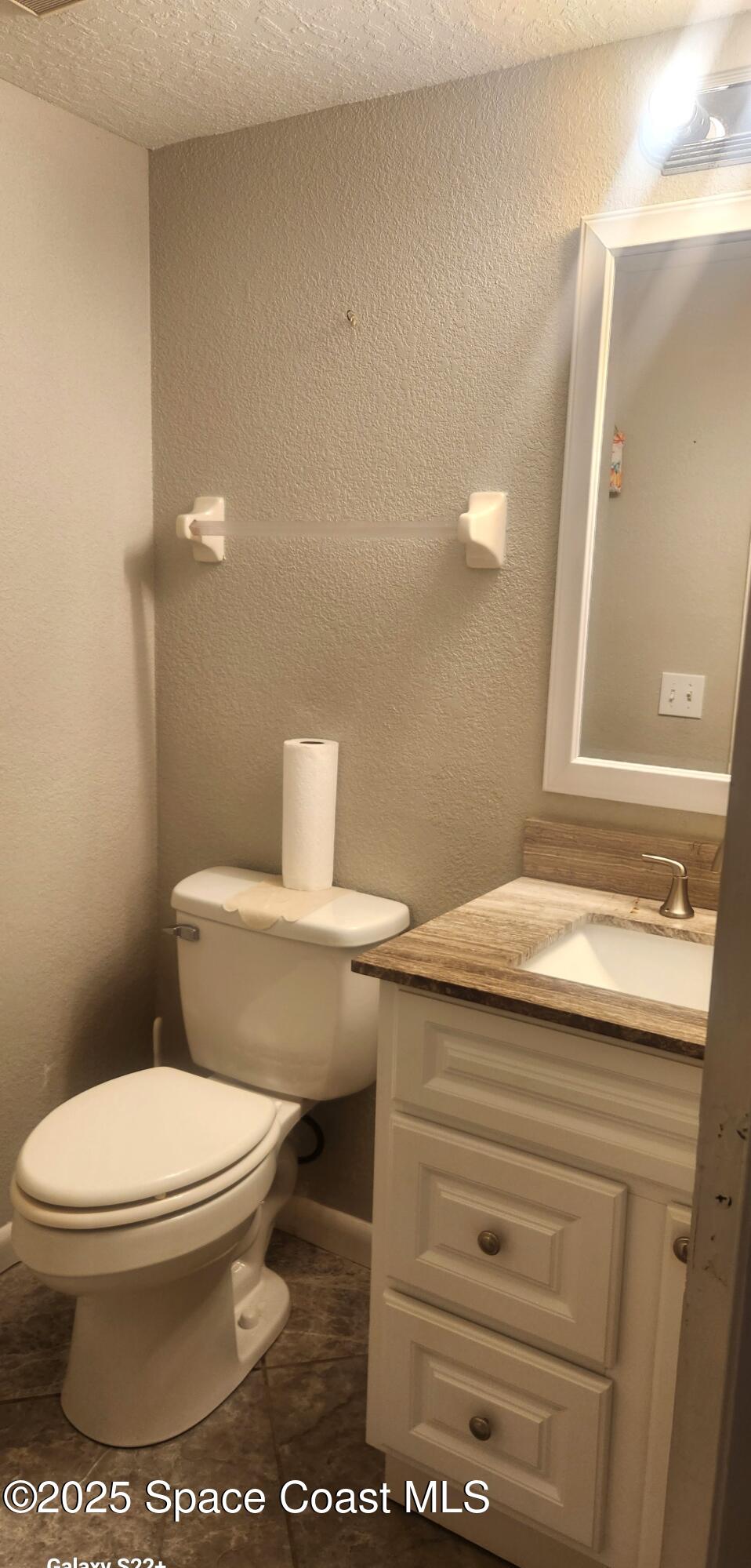 2014 Manor Drive Northeast Palm Bay, FL 32905 - Photo 5 of 15 a bathroom with a granite countertop toilet and a sink