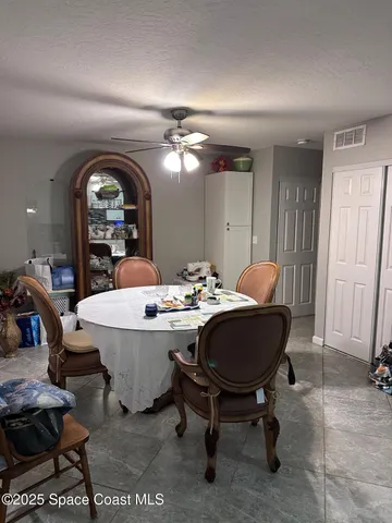 a living room with a table chairs and a dining table with wooden floor