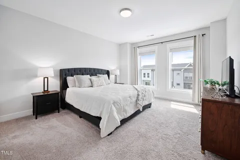 a spacious bedroom with a bed and a flat screen television