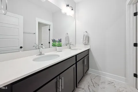 a bathroom with a double vanity sink and a mirror