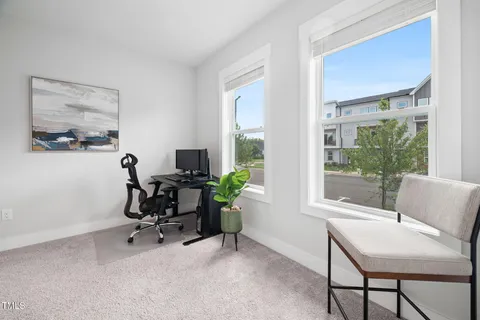 a view of a workspace with furniture and a window
