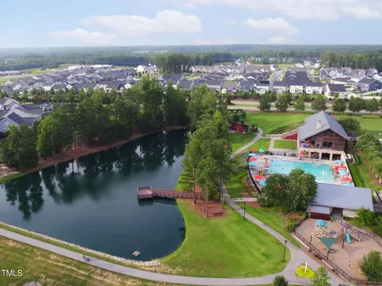 an aerial view of residential houses with outdoor space and lake view