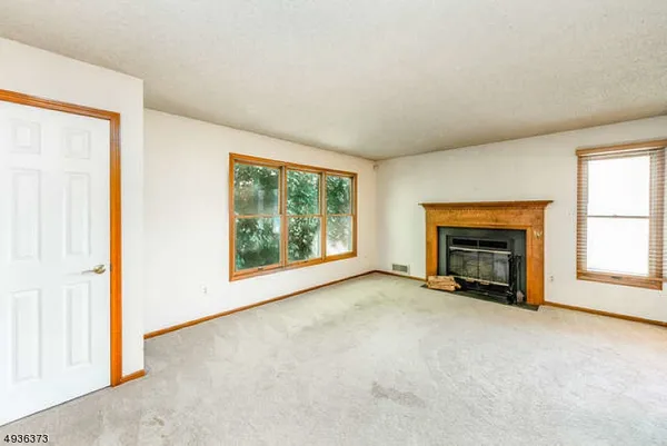 an empty room with floor to ceiling window and fireplace