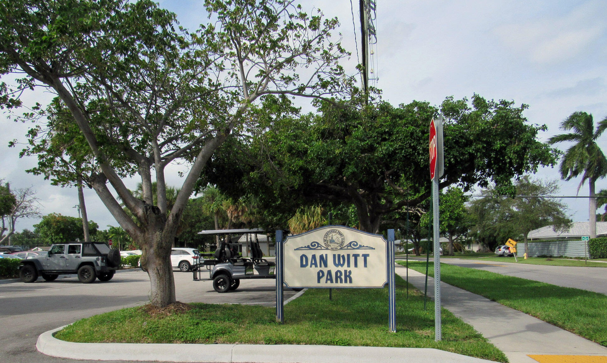 1911 Northeast 27th Court, Unit 13 Lighthouse Point, FL 33064 - Photo 50 of 61 a sign board with a bench and trees
