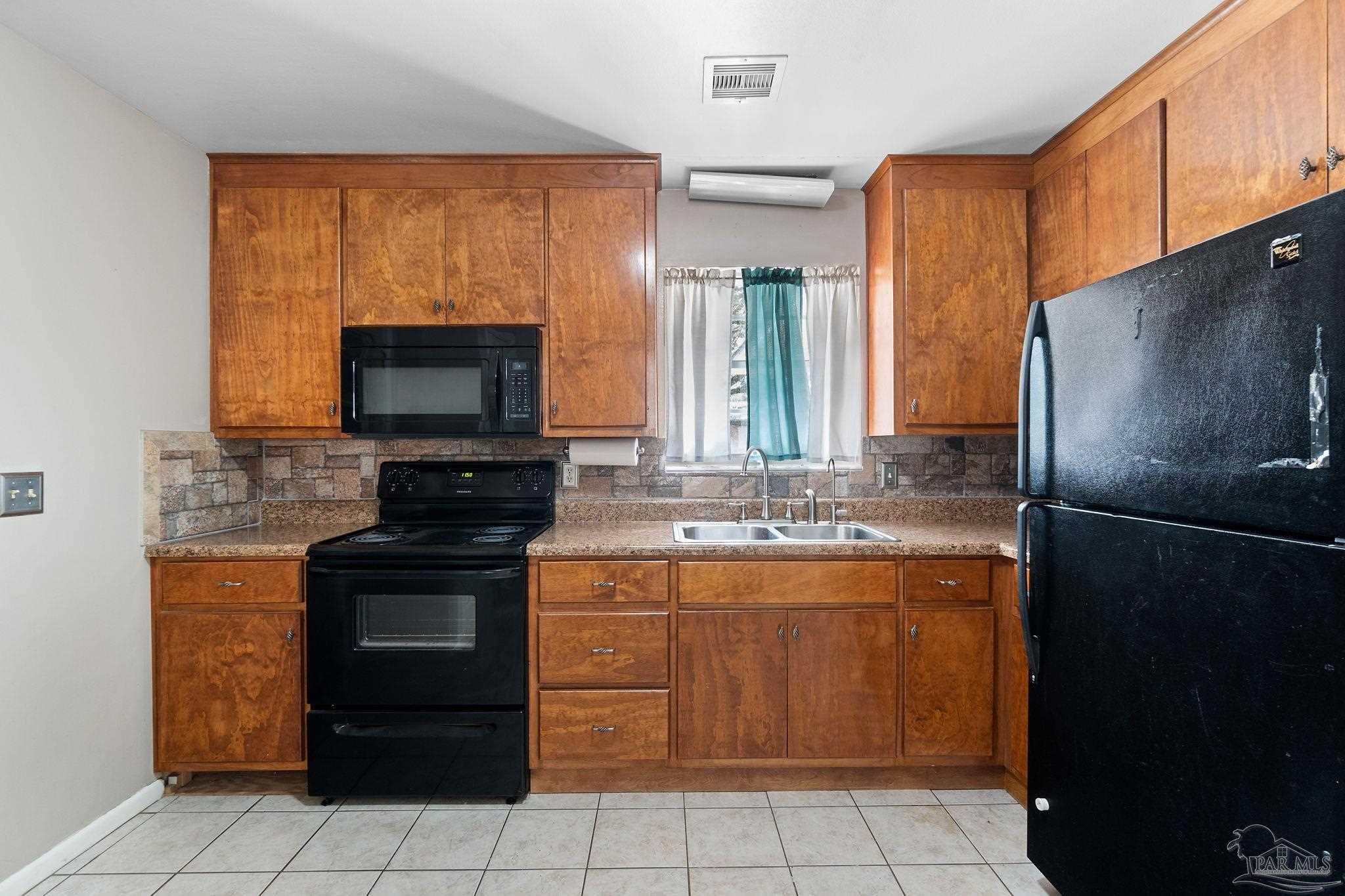 2969 Sky Crest Drive Pensacola, FL 32514 - Photo 10 of 50 a kitchen with stainless steel appliances granite countertop a stove a refrigerator and a microwave