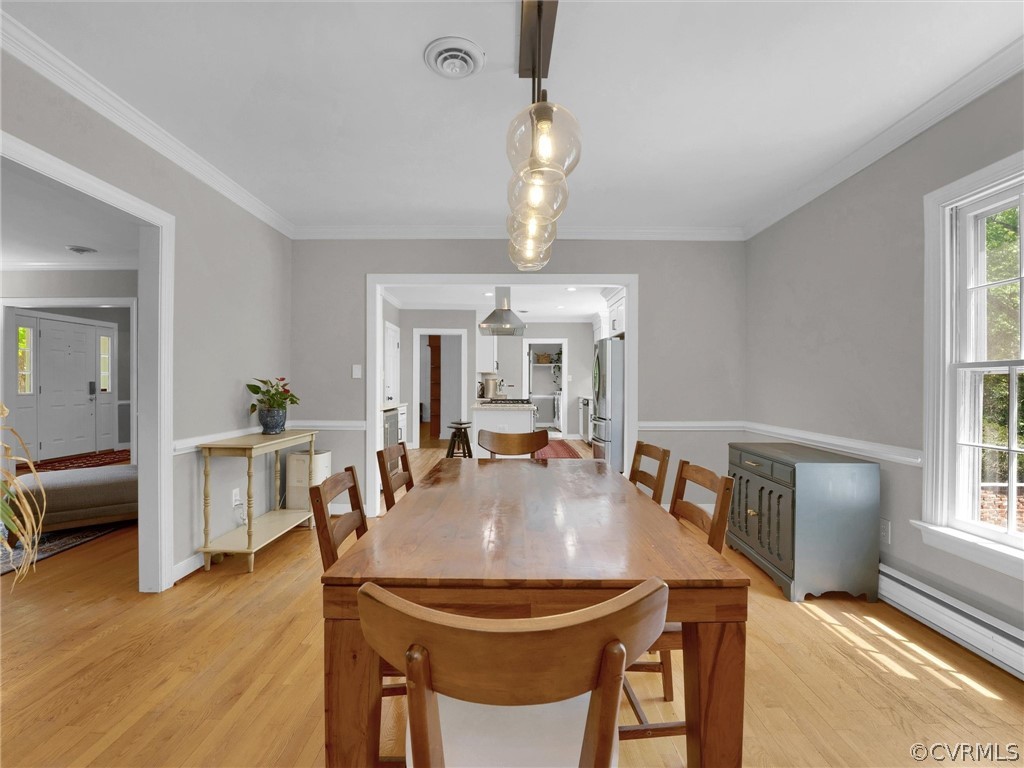 3933 Cresthill Road Chester, VA 23831 - Photo 20 of 49 a dining room with wooden floor a chandelier a wooden table and chairs